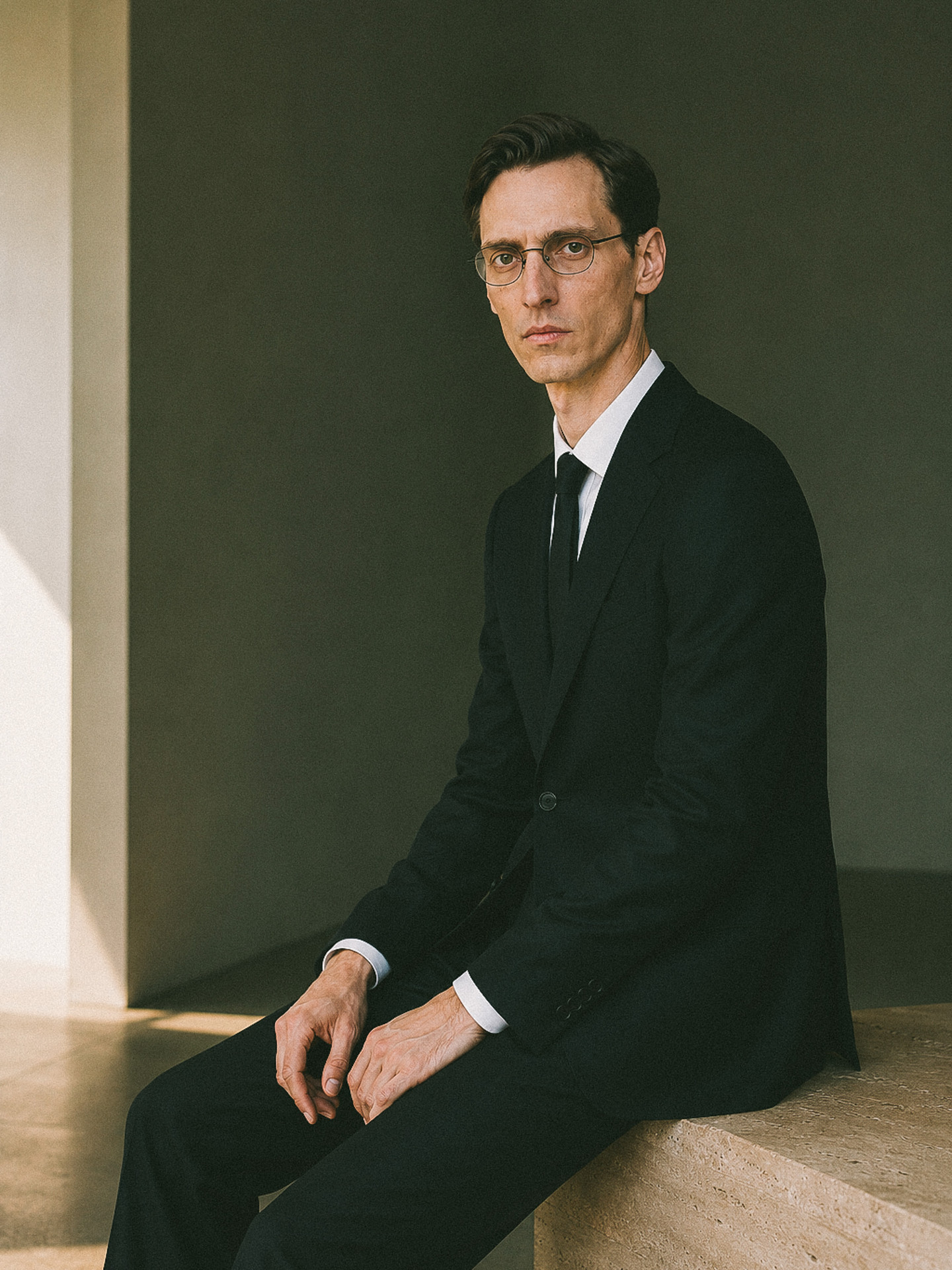 Menswear uniform suit with shirt and tie, worn seated