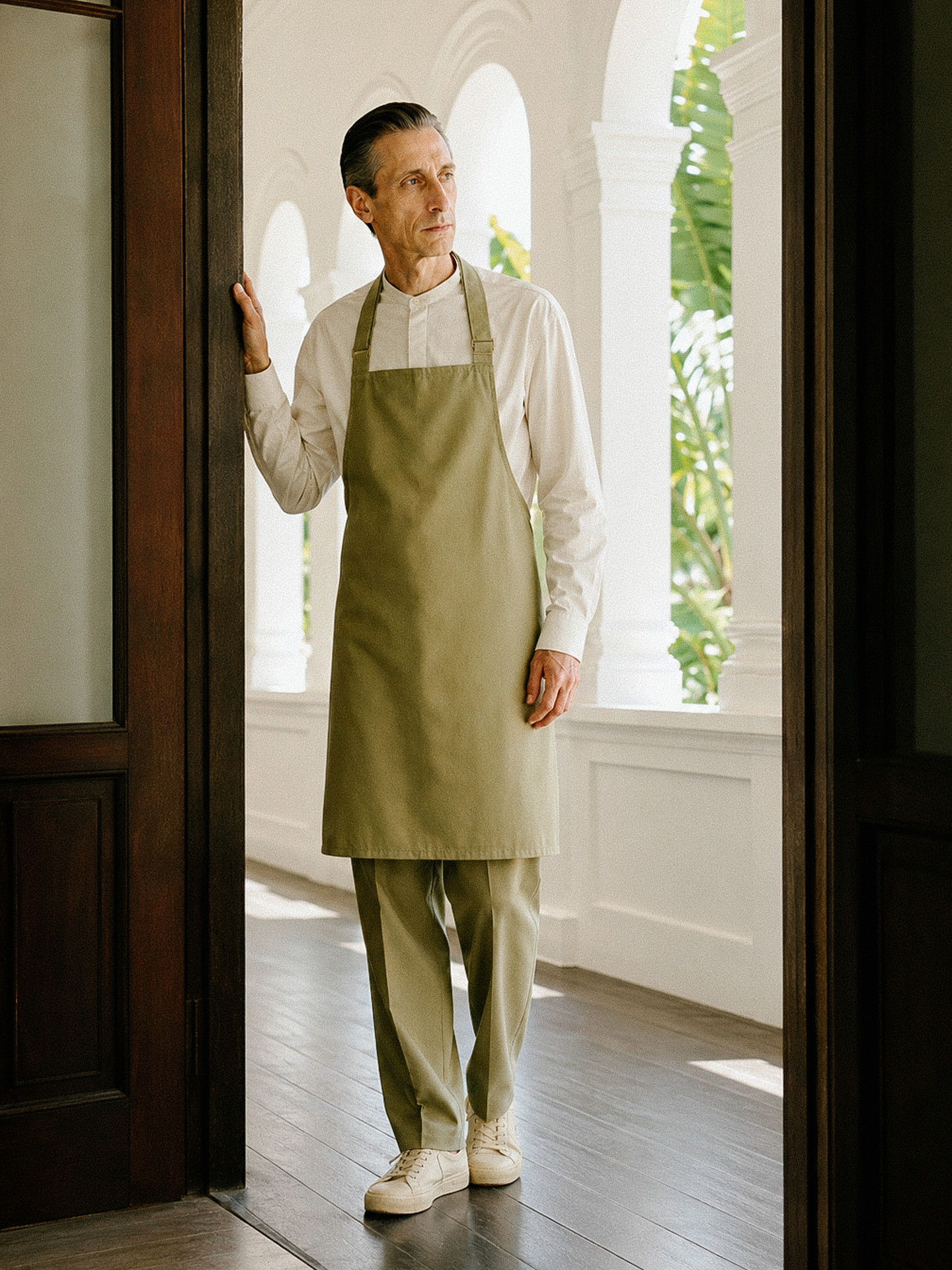 A host in the AP Café uniform at the café entrance