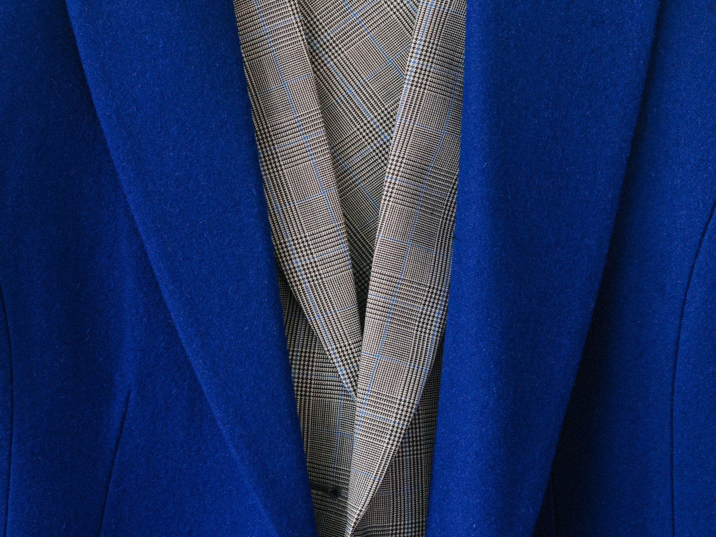 Cobalt wool coat worn open over a checked wool jacket, close detail