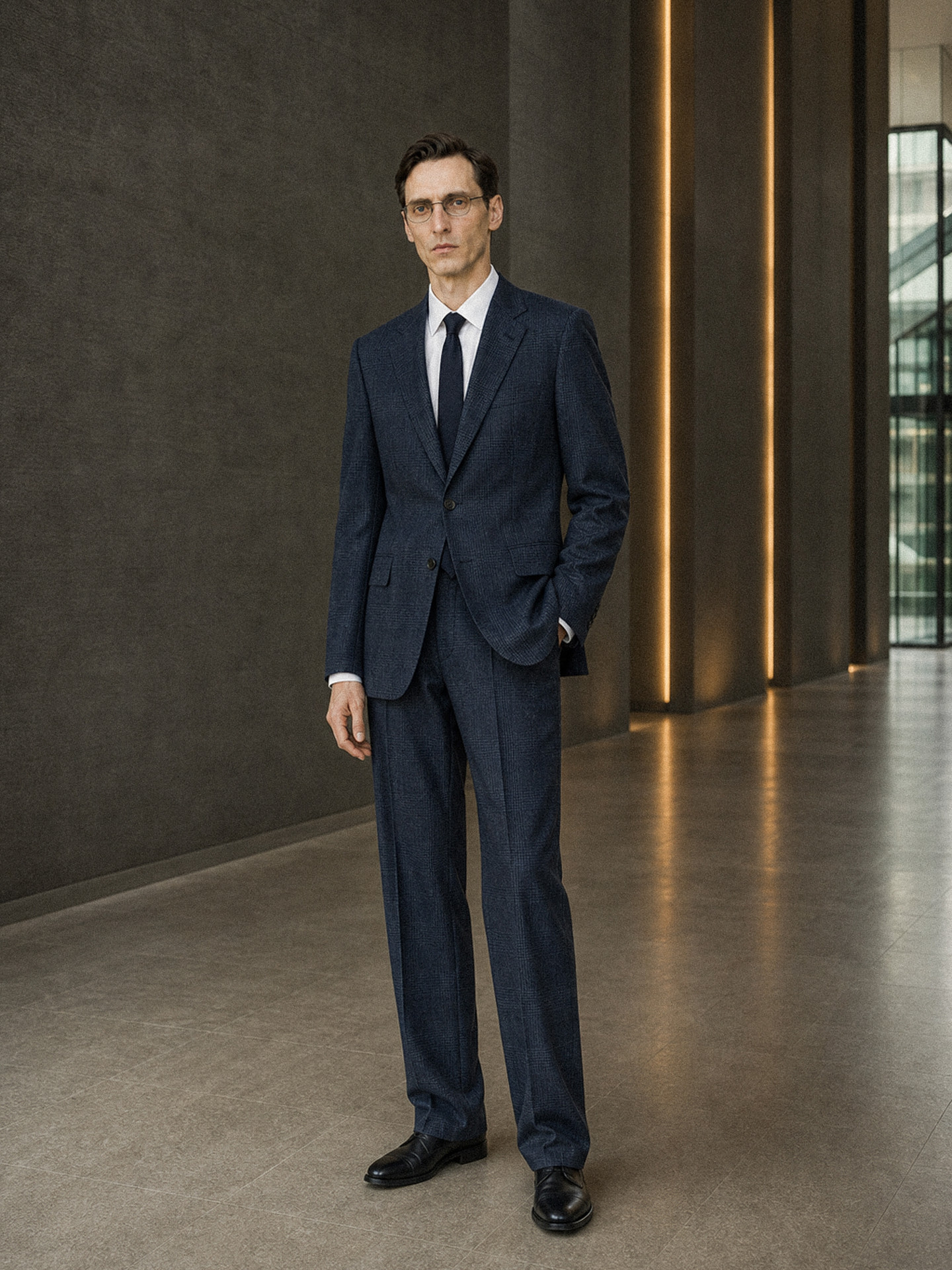 Menswear navy suit with a white shirt and tie, worn full length